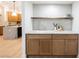 Close-up of a stylish wet bar with light wood cabinets, a marble countertop, and open shelving at 7695 Silver Wells Rd, Las Vegas, NV 89149