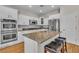 Well-lit kitchen with stainless steel appliances, white cabinets, granite counters, and an island with barstool seating at 790 Tossa De Mar Ave, Henderson, NV 89002