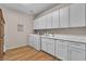 Well-lit laundry room featuring a washer, dryer, white cabinetry, and a countertop sink for added convenience at 790 Tossa De Mar Ave, Henderson, NV 89002