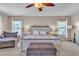 Bright main bedroom featuring a king bed, bedside tables, and seating area at 790 Tossa De Mar Ave, Henderson, NV 89002