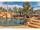 Gorgeous backyard pool features a rock waterfall and slide, surrounded by lush landscaping at 790 Tossa De Mar Ave, Henderson, NV 89002