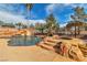 Custom backyard pool with a spa, water slide, and tropical landscaping for a resort-style living experience at 790 Tossa De Mar Ave, Henderson, NV 89002