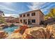 Backyard oasis featuring a sparkling pool with rock waterfall, covered patio, and lush landscaping at 790 Tossa De Mar Ave, Henderson, NV 89002