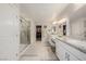 Bright bathroom with dual sinks, granite counters, glass shower and walk-in closet at 864 Firestone Ledge Ave, Henderson, NV 89012