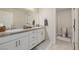 Bathroom featuring double sinks, granite countertops, and neutral-colored tile flooring with modern fixtures at 864 Firestone Ledge Ave, Henderson, NV 89012