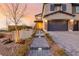 Home exterior with a three-car garage, stone accents, and landscaped yard at 864 Firestone Ledge Ave, Henderson, NV 89012