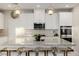 Contemporary kitchen featuring stainless steel appliances, white cabinets, and a granite island with seating at 864 Firestone Ledge Ave, Henderson, NV 89012