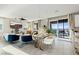 Open-concept living room featuring blue seating, mountain view from the balcony and an adjacent kitchen at 864 Firestone Ledge Ave, Henderson, NV 89012