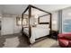 Bright bedroom featuring a canopy bed, accent chair, and ensuite bathroom at 864 Firestone Ledge Ave, Henderson, NV 89012