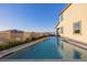 Back exterior view of a long, narrow backyard pool, surrounded by lush greenery and offering a serene escape at 864 Firestone Ledge Ave, Henderson, NV 89012