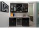 Modern bar area featuring dark cabinets, beverage cooler, and designer finishes at 91 Alta Cascata Pl, Henderson, NV 89011