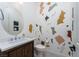 Powder room featuring decorative walls, an oval mirror, a modern vanity, and a toilet at 91 Alta Cascata Pl, Henderson, NV 89011