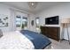 Bright bedroom featuring a dresser, a large TV, neutral carpet, and a glass door with pool view at 91 Alta Cascata Pl, Henderson, NV 89011