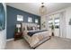 Modern bedroom with plush carpet, a striking blue accent wall, and neutral-toned furniture creating a relaxing ambiance at 91 Alta Cascata Pl, Henderson, NV 89011