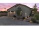 Charming single-story home featuring a paved driveway, desert landscaping, and a two-car garage, all under a beautiful sunset sky at 91 Alta Cascata Pl, Henderson, NV 89011