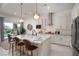 Modern kitchen with stainless steel appliances, a granite island with seating, and sleek white cabinetry at 91 Alta Cascata Pl, Henderson, NV 89011