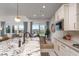 Kitchen with island seating, modern lighting, stainless steel appliances, and sliding doors to backyard at 91 Alta Cascata Pl, Henderson, NV 89011