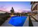 Backyard pool with integrated fire pit, lounge chairs, and manicured landscaping at 91 Alta Cascata Pl, Henderson, NV 89011