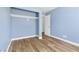 Light blue bedroom with wood-look floors and closet at 9101 Dolphin Cove Ct, Las Vegas, NV 89117