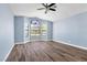 Light blue bedroom with wood floors and large window at 9101 Dolphin Cove Ct, Las Vegas, NV 89117