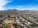 Scenic aerial shot showcasing a community near a lush golf course against a stunning mountain backdrop at 9300 Villa Ridge Dr, Las Vegas, NV 89134