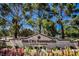 A view of the Sun City Summerlin entrance sign with a colorful flower bed and mature trees at 9300 Villa Ridge Dr, Las Vegas, NV 89134