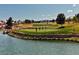 Picturesque golf course view with a pond in the foreground and golfers on the green at 9300 Villa Ridge Dr, Las Vegas, NV 89134