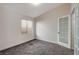 A cozy bedroom with gray carpet, natural light from the window, and a double-door entry at 9995 Yellow Canary Ave, Las Vegas, NV 89117