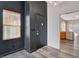 Entryway features a black door, a window, and leads into the kitchen with wood floors at 9995 Yellow Canary Ave, Las Vegas, NV 89117