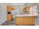 Eat-in kitchen featuring a peninsula, wood floors, white cabinets, and white countertops at 9995 Yellow Canary Ave, Las Vegas, NV 89117