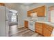 Kitchen with a white refrigerator, stove, wood cabinets, and wood floors at 9995 Yellow Canary Ave, Las Vegas, NV 89117