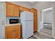 Kitchen featuring a microwave, wood cabinets, white refrigerator, and wood floors at 9995 Yellow Canary Ave, Las Vegas, NV 89117