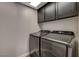 A laundry room with sleek, modern washer and dryer units, plus ample storage at 9995 Yellow Canary Ave, Las Vegas, NV 89117