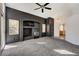 Spacious living room with a ceiling fan, grey carpet, built-in shelves and fireplace at 9995 Yellow Canary Ave, Las Vegas, NV 89117