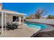 Backyard view of the swimming pool with a covered patio and outdoor seating at 9995 Yellow Canary Ave, Las Vegas, NV 89117