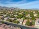 Expansive aerial view showcasing the neighborhood with mountain views and manicured landscaping at 10528 Meadow Mist Ave, Las Vegas, NV 89135