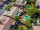 An aerial view displays a house with a private pool and lush landscaping in a suburban neighborhood at 10528 Meadow Mist Ave, Las Vegas, NV 89135