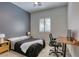 Neutral bedroom with a large window, a ceiling fan, and a simple desk setup at 10528 Meadow Mist Ave, Las Vegas, NV 89135