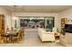 Bright and airy living room featuring an open floor plan, hardwood floors, and sliding doors to the patio at 10528 Meadow Mist Ave, Las Vegas, NV 89135