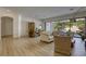 Bright and airy living room featuring an open floor plan, hardwood floors, and sliding doors to the patio at 10528 Meadow Mist Ave, Las Vegas, NV 89135