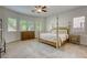 Cozy main bedroom features soft carpet, natural light, and a classic four-poster bed, exuding charm and comfort at 10528 Meadow Mist Ave, Las Vegas, NV 89135