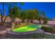 Beautiful pool with rock features and illuminated water in a serene backyard setting at 10528 Meadow Mist Ave, Las Vegas, NV 89135