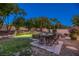 Inviting backyard pool area with a rock waterfall feature and an outdoor dining set at 10528 Meadow Mist Ave, Las Vegas, NV 89135