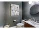 Modern powder room with dark gray walls, a floating sink, and abstract art at 10528 Meadow Mist Ave, Las Vegas, NV 89135