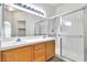 Bathroom featuring double vanity, wood cabinets, large mirror and glass enclosed shower with clean, modern design at 107 Topsail Dr, Boulder City, NV 89005