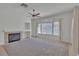 Comfortable living room with a cozy fireplace, neutral walls, and large windows offering natural light at 107 Topsail Dr, Boulder City, NV 89005