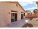 A view of the backyard featuring a concrete patio, stucco walls, and a neighboring residence at 10765 Muscari Way, Las Vegas, NV 89141