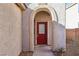 Inviting front entrance featuring a red door with arched entryway and desert landscaping at 10765 Muscari Way, Las Vegas, NV 89141