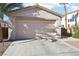 A spacious two-car garage with concrete driveway and desert landscaping at 10765 Muscari Way, Las Vegas, NV 89141