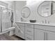 Elegant bathroom with double vanity, round mirrors and a glass enclosed shower at 108 Kimberlite Dr, Henderson, NV 89011